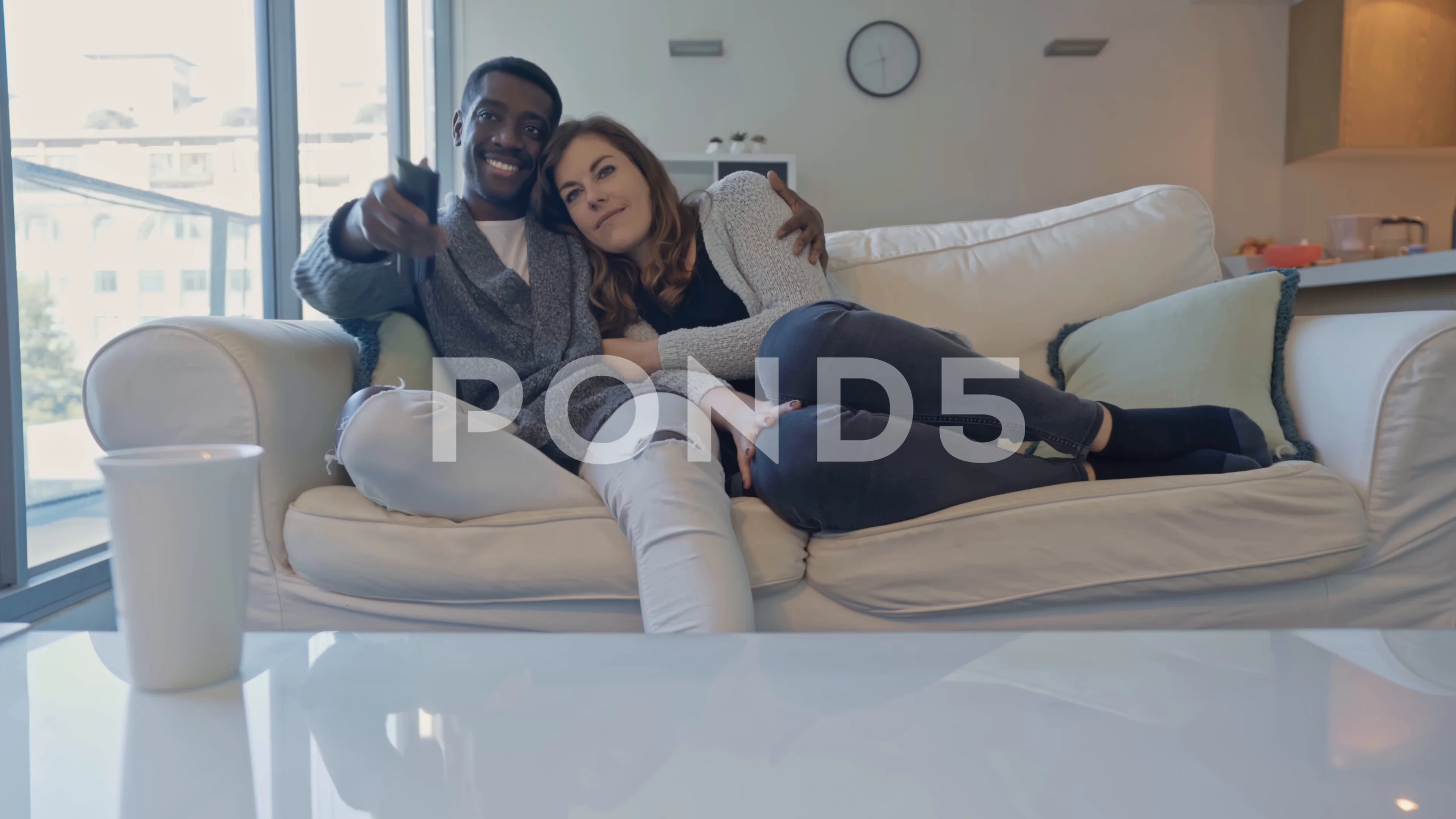 Beautiful Black Couple Cuddling On Couch At Home, Watching Tv