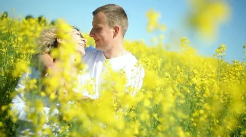 Sweet couple in a field of rape Stock Footage 11110618