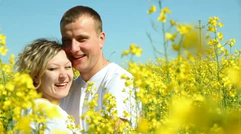 Sweet couple in a field of rape Stock Footage 11111593