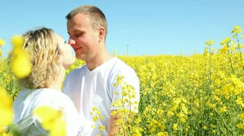 Sweet couple in a field of rape Stock Footage 11112640