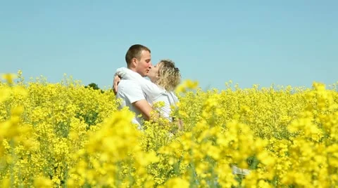 Sweet couple in a field of rape Stock Footage 11129009