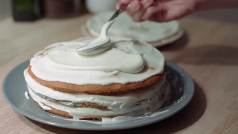 Sweet cream being applied and spread over the sponge cake layer, cake decor.. Stock Footage 302099109
