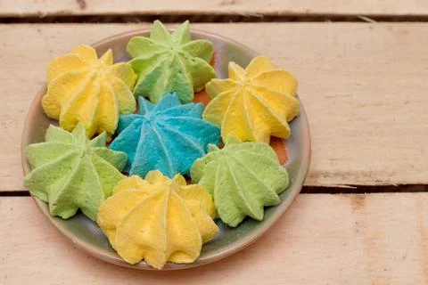 Sweet, crispy, multi-colored meringue in a plate. Stock Photos