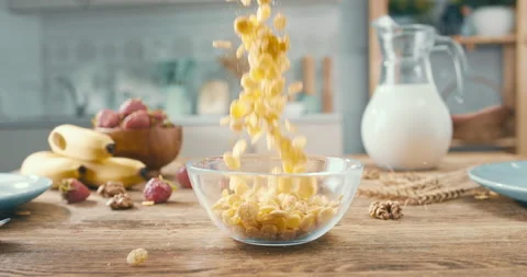 Sweet crusty corn flakes falling into glass bowl. Crispy vegan cereal dropping 스톡 동영상 154872100