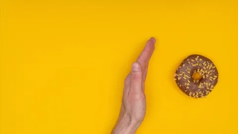Sweet donuts appear from the hand and then disappear. Stop motion animation. Stock Footage 128922720