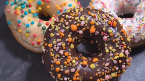 Sweet donuts spinning on a dark background. Traditional American sweetness Stock Footage 103092097