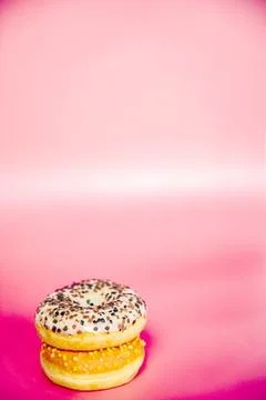 Sweet donuts stacked in a stack on a pink background. Copy space, various glaze Stock Photos