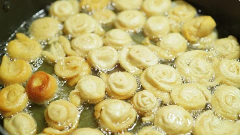 Sweet dough rosettes frying in hot oil inside a skillet Stock Footage 346809704