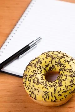 Sweet doughnut and spiral notebook Stock Photos