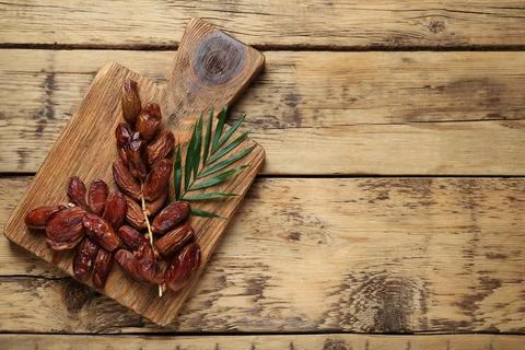 Sweet dried dates with green leaf on wooden table, top view. Space for text 스톡 사진