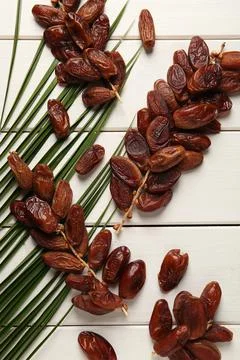 Sweet dried dates with palm leaf on white wooden table, flat lay 스톡 사진
