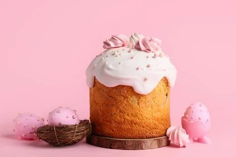 Sweet Easter cake with meringue and painted eggs on pink background Stock Photos