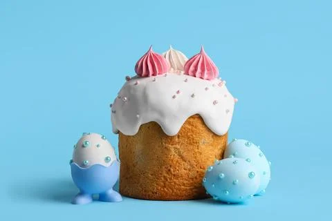 Sweet Easter cake with meringue and painted eggs on blue background Stock Photos
