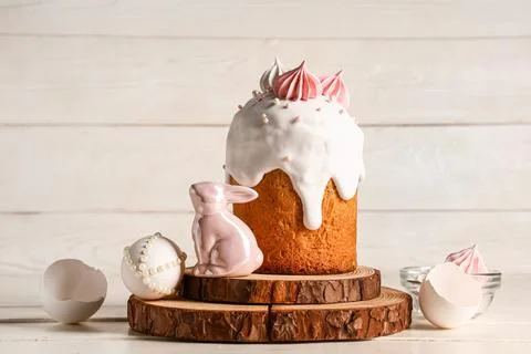 Sweet Easter cake with meringue, egg and toy bunny on white wooden background Stock Photos