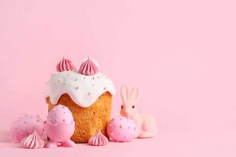 Sweet Easter cake with meringue, painted eggs and toy bunny on pink backgroun Stock Photos