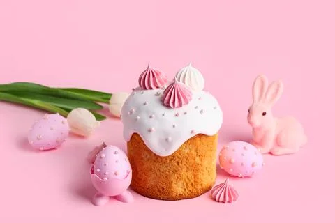 Sweet Easter cake with meringue, painted eggs and toy bunny on pink backgroun Stock Photos