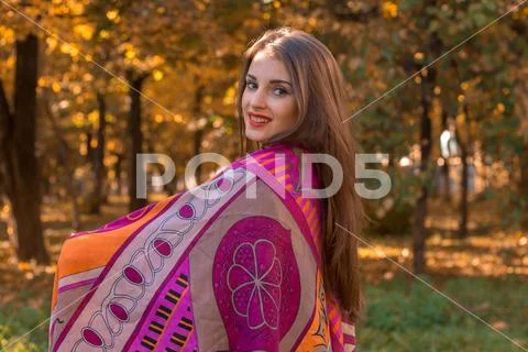 Sweet girl keeps the big pink scarf on the shoulders and smiles Stock Photos
