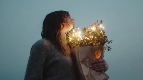 Sweet girl squeezes to herself bouquet of flowers with lights Stock Footage 190334341