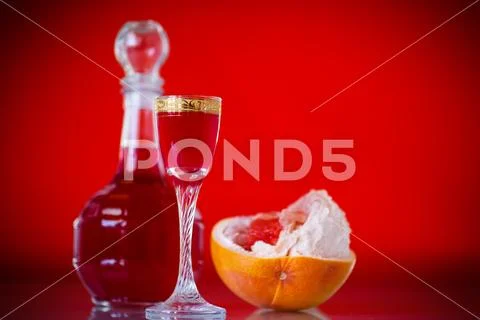 Sweet grapefruit alcoholic cordial in the decanter with a glass Stock Photos