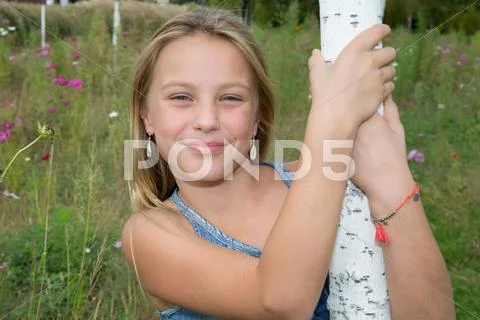 Sweet, happy and smiling young girl in a park Stock Photos