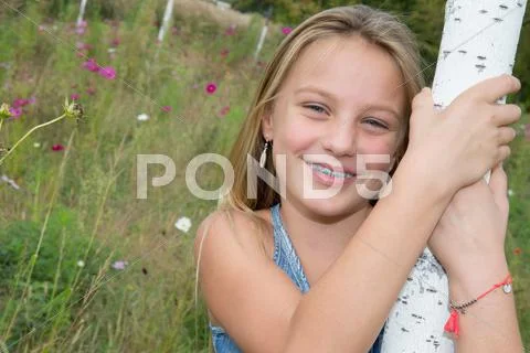 Sweet, happy and smiling young girl in a park Stock Photos