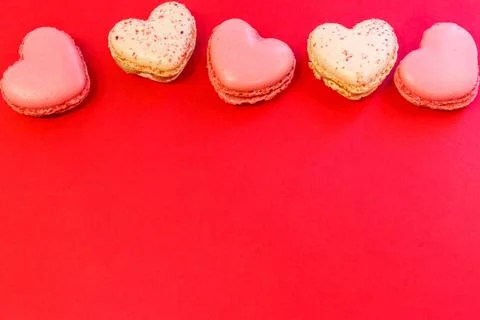 Sweet heart shaped macaroons on red background. Top view, copy space Stock Photos
