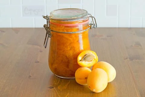 Sweet homemade organic apricot jam and fresh apricots on wooden table Stock Photos