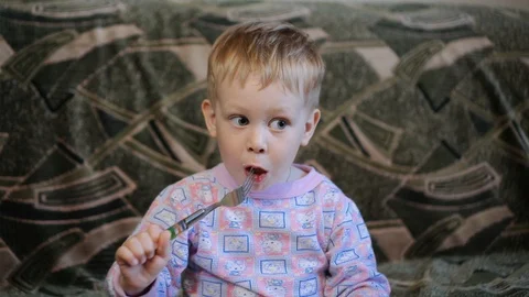 Sweet little boy eats, then gives plate to father. Cute small child is at home Stock Footage 123394593