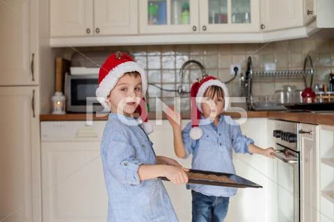 Sweet little children, boy brothers, preparing ginger bread cookies for the o Stock Photos