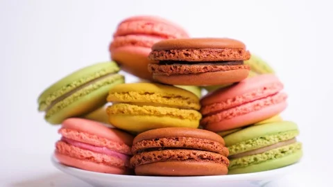 Sweet macaroons on plate with multi colored confectionery dressing. Close up. Stock Footage 107413410