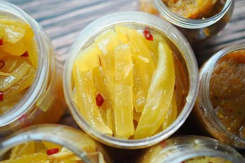 Sweet mango slices pickle in jars on a wooden table Stock Photos