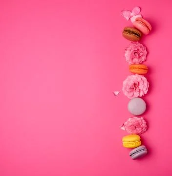 Sweet multi-colored macarons with cream and a pink rose bud Fotos Stock