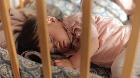 Sweet nap of 1 year old girl with pink shirt in her crib. Stock Footage 220426462