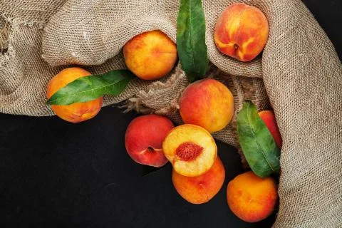 Sweet Peaches on a sharp stone table with a cloth of burlap and a slice of ju Stock Photos