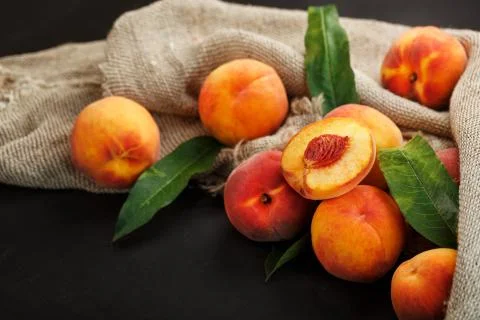Sweet Peaches on a sharp stone table with a cloth of burlap and a slice of ju Stock Photos
