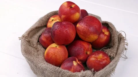 Sweet peaches on the table with burlap cloth. organic fruit on a white Stock Footage 157684976
