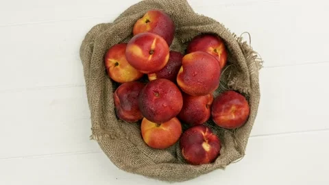 Sweet peaches on the table with burlap cloth. organic fruit Stock Footage 157687836
