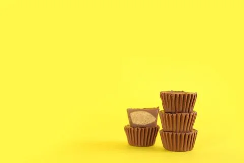 Sweet peanut butter cups on yellow background. Space for text Stock Photos