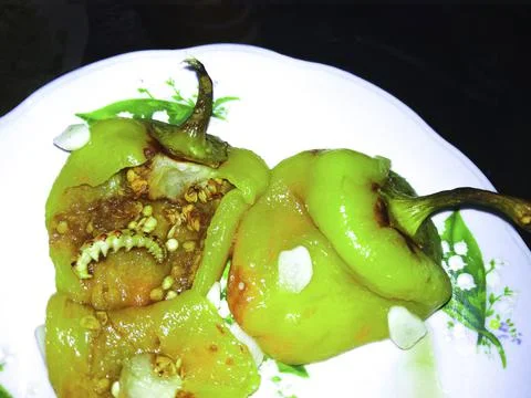Sweet pepper with worm, paprika,  fried spread out on a plate, creepy background Stock Photos