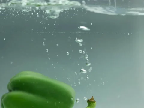 Sweet peppers fall into the water Stock Footage 137078529