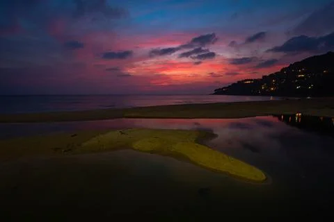 Sweet pink sky at sunset reflection in the beach puddle. Stock Photos