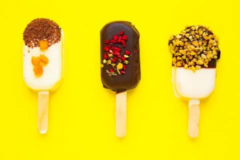 Sweet popsicles on yellow background. Mini dessert close up. Foto stock