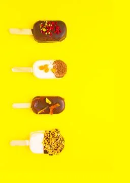 Sweet popsicles on yellow background. Mini dessert close up. Stock Photos