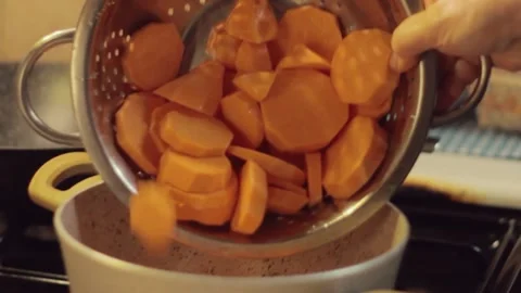 Sweet potatoes are placed in the pot and the stove is turned on. Stock Footage 250270135