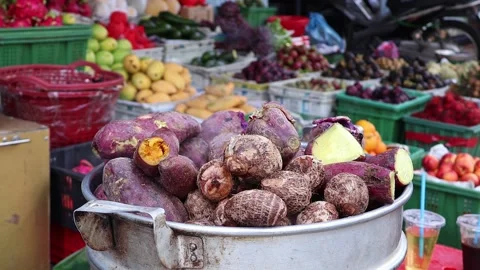 Sweet potatoes cook in a steaming pot at Vietnamese vegetable market Stock Footage 343431815