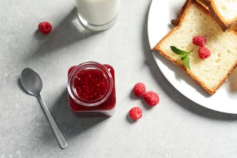 Sweet raspberry jam and toasts for breakfast on table, flat lay Foto stock