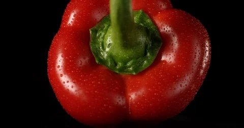 Sweet red bell pepper rotating on a black background with water drops. Shot on Stock Footage 106480835