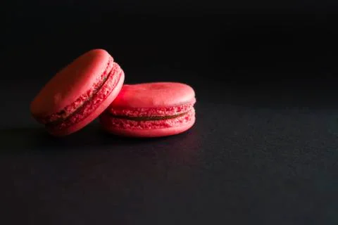 Sweet red french macaron on dark background. Stock Photos