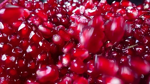 Sweet red juice is flowing down the ripe pomegranate grains Stock Footage 293130863