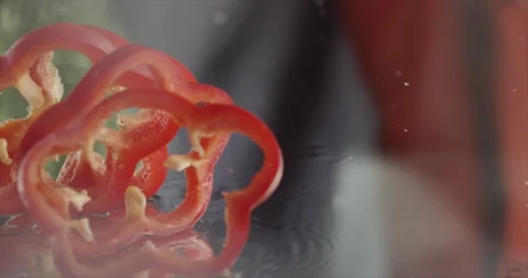 Sweet red pepper rings fall on a mirror surface Video stock 198344465